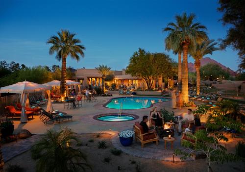 a group of people sitting around a pool at a resort at The Hermosa Inn in Phoenix