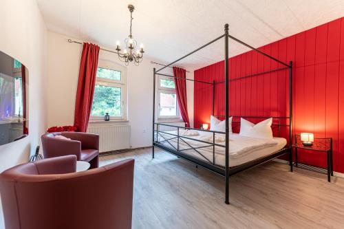 um quarto com uma cama de dossel e uma parede vermelha em Haus am Malerweg em Bad Schandau