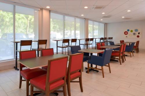 a dining room with tables and chairs and windows at Holiday Inn Express Towson- Baltimore North by IHG in Towson