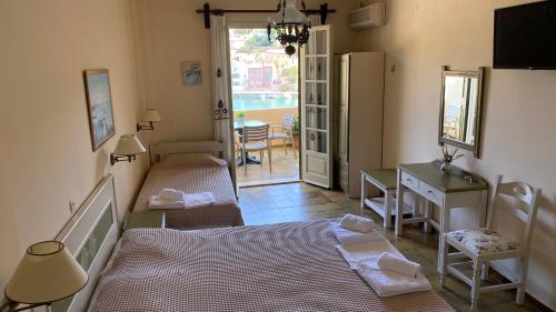 a bedroom with a bed and a table and a door at Linardos Apartments in Asos