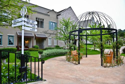 a garden with a gate and signs in front of a building at Thames Valley Khao Yai - SHA Plus in Mu Si