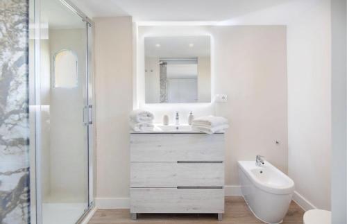 a white bathroom with a sink and a mirror at AMAZING DUPLEX NEXT TO THE BEACH IN MARBELLA in Marbella