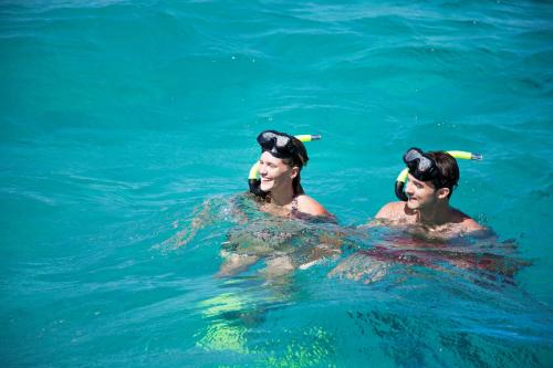 a man and a woman swimming in the water at Veranda Grand Baie Hotel & Spa in Grand-Baie