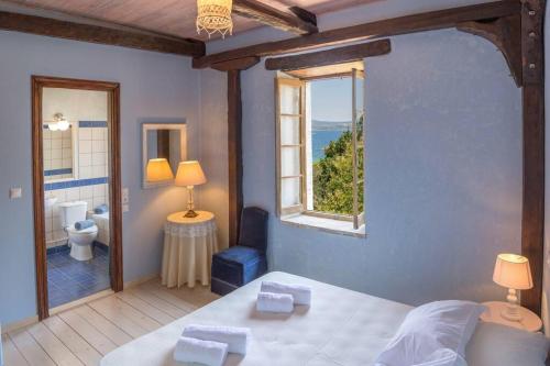 a bedroom with a bed and a window and a bathroom at Villa Rocca in Nikiana