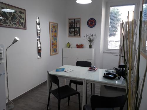 a room with a desk with chairs and a table at Affittacamere Le Farfalle in La Spezia