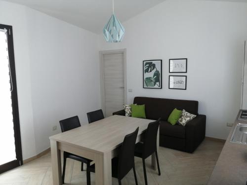 sala de estar con mesa y sofá en Appartamento Monte Granatico 02, en SantʼAntìoco