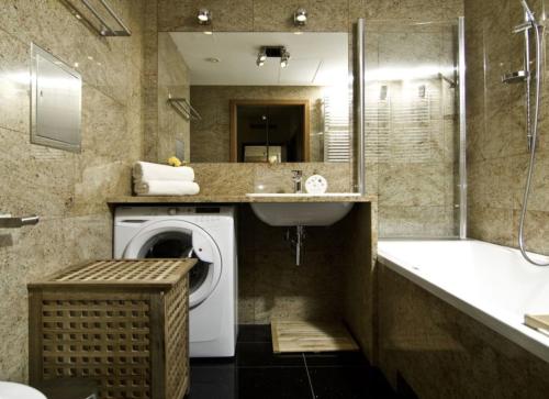 een badkamer met een wasmachine, een wastafel en een bad bij Main Street Apartment - Old Town in Wrocław