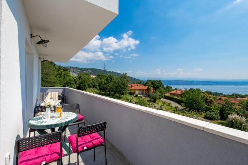 a balcony with a table and chairs and a view of the ocean at Villa Zita Lovran in Opric