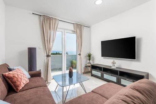 a living room with a couch and a flat screen tv at Villa Zita Lovran in Opric