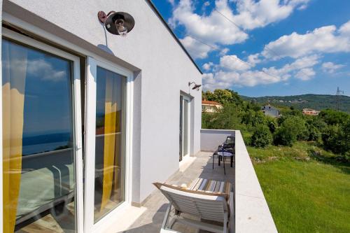 a balcony with chairs and a view of the ocean at Villa Zita Lovran in Opric