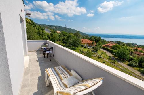 a balcony with a couch and a view of the water at Villa Zita Lovran in Opric