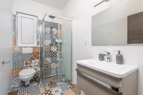 a bathroom with a shower and a toilet and a sink at Villa Zita Lovran in Opric
