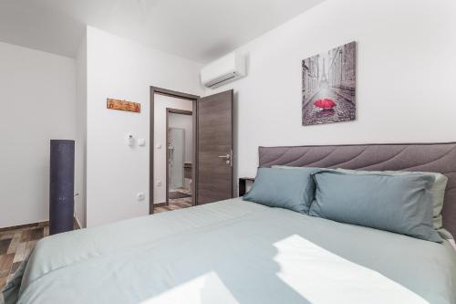 a bedroom with a large bed with blue pillows at Villa Zita Lovran in Opric