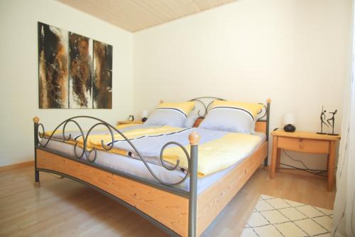 um quarto com uma cama com uma estrutura de metal em Ferienwohnung Am Wingert em Sankt Martin