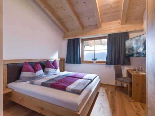 1 dormitorio con cama, escritorio y ventana en Bergappartements Reithammer - Ellmau en Ellmau