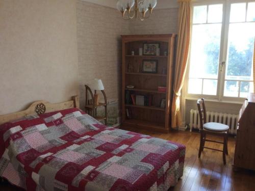 a bedroom with a bed with a checkered blanket and a window at MONT BLANC 20 LE REVARD in Pugny-Chatenod