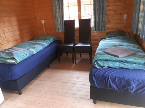 a room with two beds and two chairs in a cabin at Alte Mühle 2 in Licherode