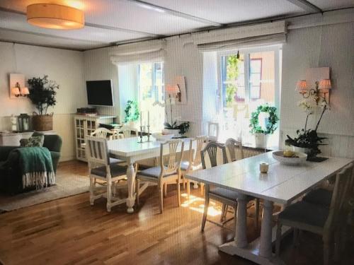 a living room with a dining room table and chairs at Hotell Bäckagården in Ystad