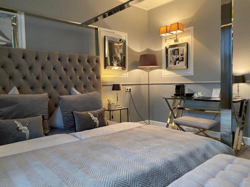 a bedroom with a large bed with a large headboard at Boutique Hotel Villa Sarah in Düsseldorf