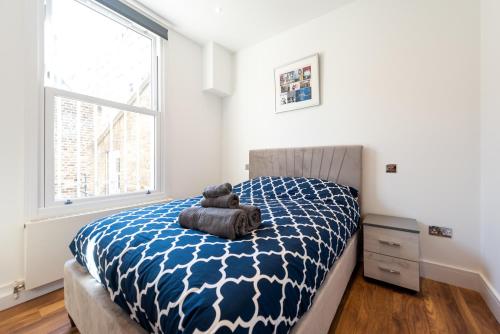un orsacchiotto seduto su un letto in una camera da letto di Hyde Park Apartment (SS1) a Londra