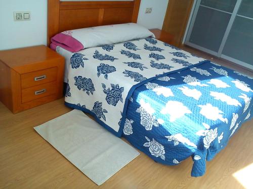 ラシェにあるApartamentos de uso turisticoのベッドルーム1室(青と白の掛け布団付きのベッド1台付)