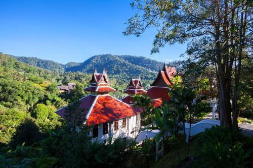 a house in the hills with trees and mountains at Panviman Chiang Mai Spa Resort in Mae Rim