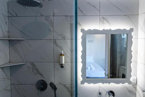 a bathroom with a shower with a mirror at Yiasemi Apartments in Iraklitsa