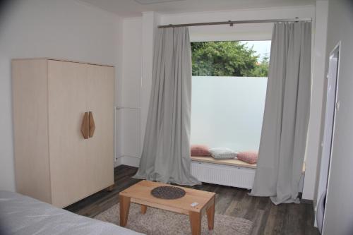 a bedroom with a bed and a window and a table at pAt - a spacious place near the station and center in Spišská Nová Ves