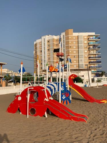 un parque infantil en la arena en una playa en LAS PERLAS - 1º Linea, en Denia