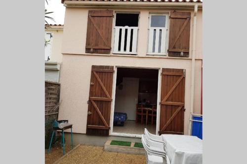 Cette maison dispose de portes en bois et d'un balcon. dans l'établissement Maison totalement renovée à Marseillan - 6 couchages - près de l'étant de Thau, à Marseillan