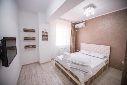 a small bedroom with a bed and a television at Moonlight Apartments in Mamaia