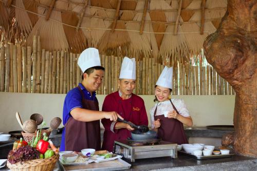 a group of three chefs preparing food in a kitchen at Panviman Chiang Mai Spa Resort in Mae Rim