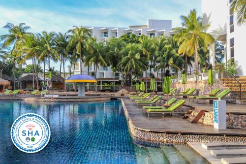 a pool at a resort with chairs and palm trees at Hard Rock Hotel Pattaya - SHA Extra Plus in Pattaya