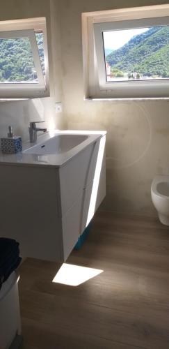 a bathroom with a sink and a toilet with a window at Rocce sul Mare in Deiva Marina