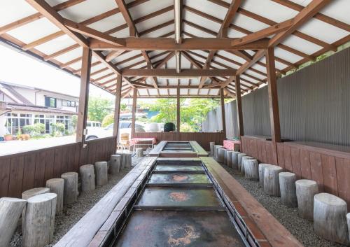 a covered walkway with wooden beams and wooden logs at Hanamizuki in Yamanakako