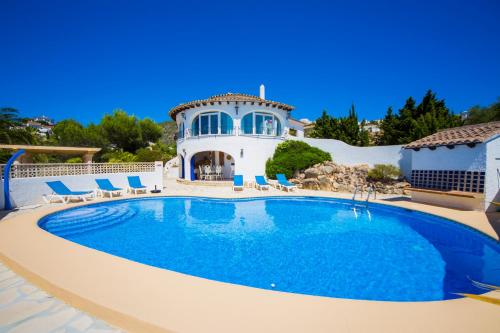 a swimming pool in front of a house at Mirador al Sur in Moraira