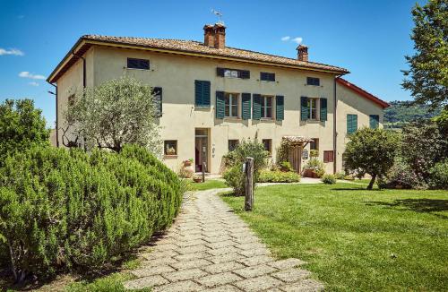 una grande casa con un sentiero in pietra davanti di CUGUSI BnB a Montepulciano