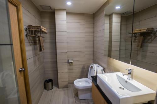 a bathroom with a toilet, sink, and shower at JC Mark Hotel in Bintulu