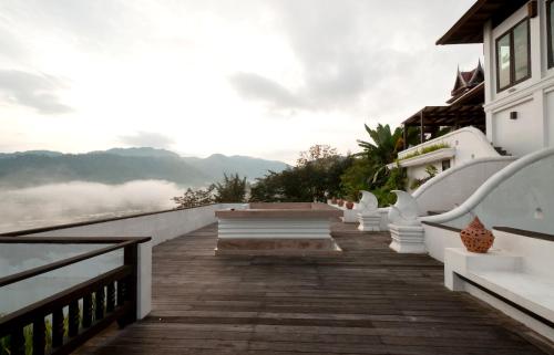 a wooden walkway leading to a house with a view at Panviman Chiang Mai Spa Resort in Mae Rim