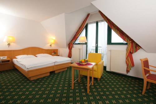 ein Hotelzimmer mit einem Bett und einem Tisch in der Unterkunft Etzhorner Krug in Oldenburg