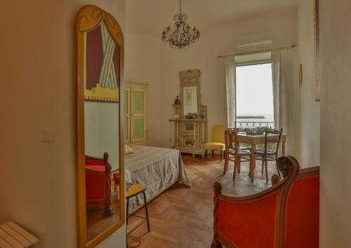 パレルモにあるAmazing Sea View in Historic Building in Downtown by Wonderful Italyの鏡、ベッド、テーブルが備わる客室です。