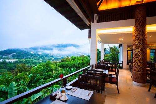 a restaurant with a balcony with tables and chairs at Panviman Chiang Mai Spa Resort in Mae Rim