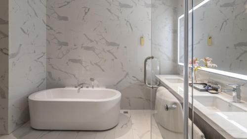 a white bathroom with a sink and a tub at Hyatt Place Changsha Airport in Changsha