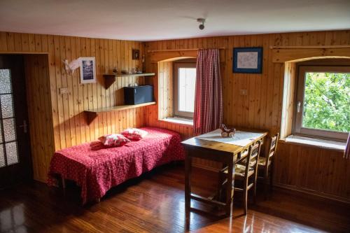 una camera con un letto e un tavolo e due finestre di Appartamenti Maison Guyon a Chambave