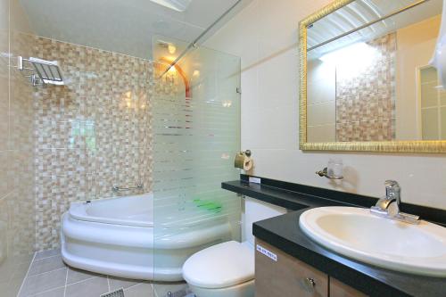 a bathroom with a sink and a toilet and a mirror at Yejeon Pension in Gyeongju