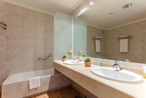 a bathroom with two sinks and a large mirror at Holiday Premium Resort in Benalmádena