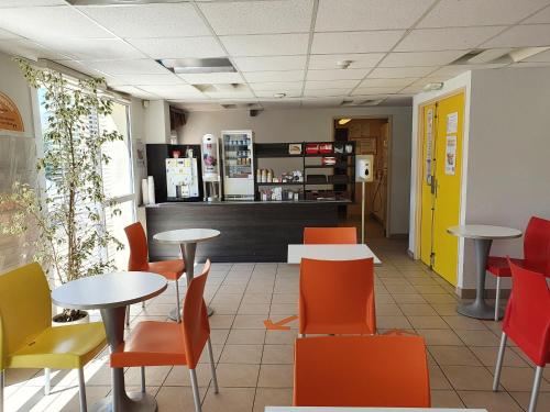 un restaurant avec des tables, des chaises et un comptoir dans l'établissement Première Classe Annemasse Ville La Grand, à Ville-la-Grand