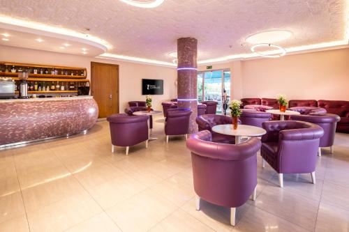 un restaurante con mesas y sillas de color púrpura y un bar en Hotel Castellucci, en Bellaria-Igea Marina