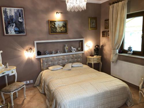 a bedroom with a bed and two tables and a chandelier at Villa Natalia in Ayia Napa