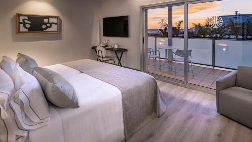 a bedroom with a large bed and a balcony at Bel Air in Castelldefels